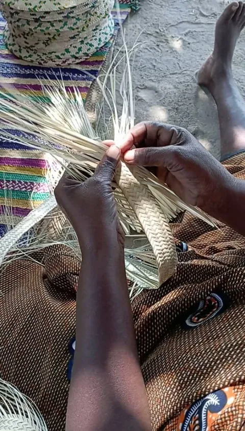 Hands weaving palm leaves